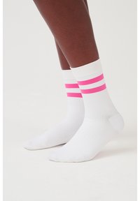 Weiße Knöchelsocken mit zwei horizontalen rosa und weißen Streifen am oberen Rand. Das Material ist gerippt und glatt, entworfen für Komfort und Unterstützung.