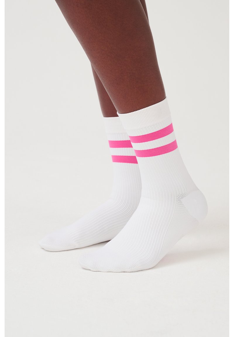 Weiße Knöchelsocken mit zwei horizontalen rosa und weißen Streifen am oberen Rand. Das Material ist gerippt und glatt, entworfen für Komfort und Unterstützung.