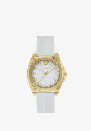 Ceas Versace cu finisaj auriu, cadran alb texturat, marcaje orare aurii, logo Medusa și curea de cauciuc alb cu detalii ornamentale.