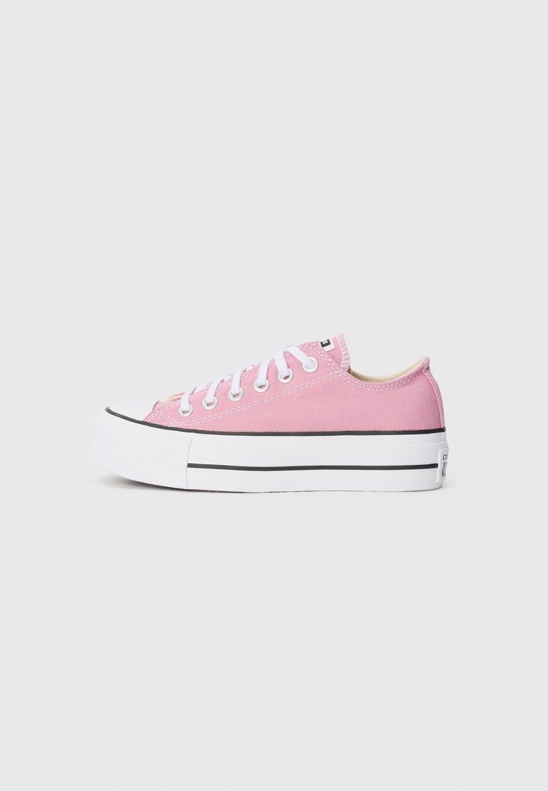 Pink canvas sneakers with a classic low-top design, white rubber toe cap, and black accent stripes on the sole. Flat white laces.