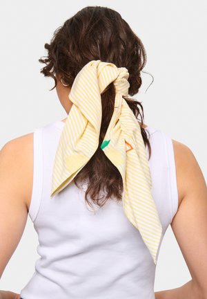 Gulstribet tørklæde bundet i håret, med grønne og orange broderede detaljer. Stoffet ser blødt ud med en let tekstur.