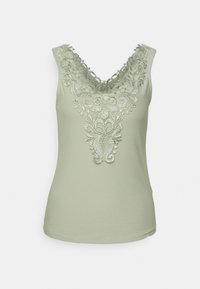 Débardeur vert clair sans manches avec décolleté en V plongeant, orné de broderies florales complexes sur le devant et les épaules.
