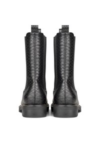 Botas de tobillo de cuero negro con un patrón de piel de serpiente texturizada, paneles laterales elásticos y una suela de goma plana con acentos de costura sutiles.