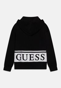 Schwarzer Kapuzenpullover mit weißem Band, das das "GUESS"-Logo trägt. Weiche Textur, gerippte Bündchen und Saum. Einfaches Design, keine zusätzlichen Muster.