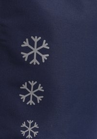 Marinfärgad textil med tre vita snöflingemönster i olika storlekar, med skarpa kanter och en jämn yta.