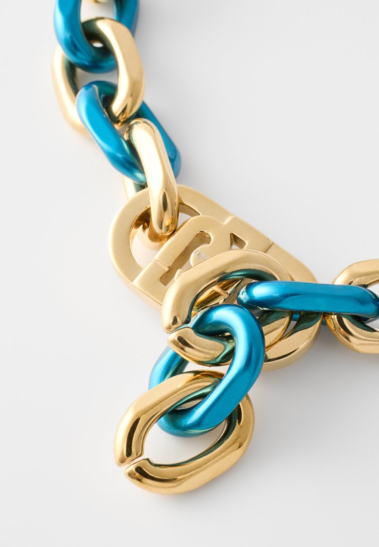 Chunky chain necklace featuring glossy turquoise and gold links with a mix of oval and rounded shapes, showcasing contrasting colors and textures.