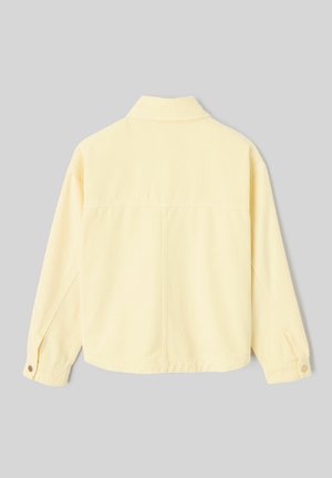 Veste jaune pâle à manches longues avec col, poignets boutonnés et couture visible courant verticalement au centre du dos.