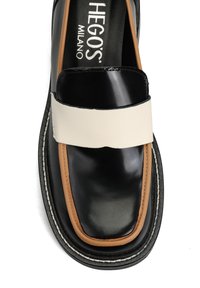 Czarny skórzany but z jasnobrązowym obszyciem i szerokim białym paskiem na górze, z logo „Hegos Milano” wewnątrz.