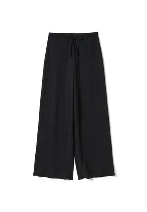 Zwarte wijde broek met een gestructureerde stof en een trekkoord in de taille, plat gelegd tegen een witte achtergrond.