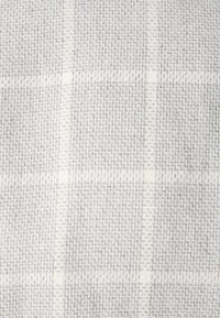 Lichtgrijs geweven stof met een fijn ruitpatroon. Gladde textuur met een subtiele glans, ideaal voor bekleding of kleding.