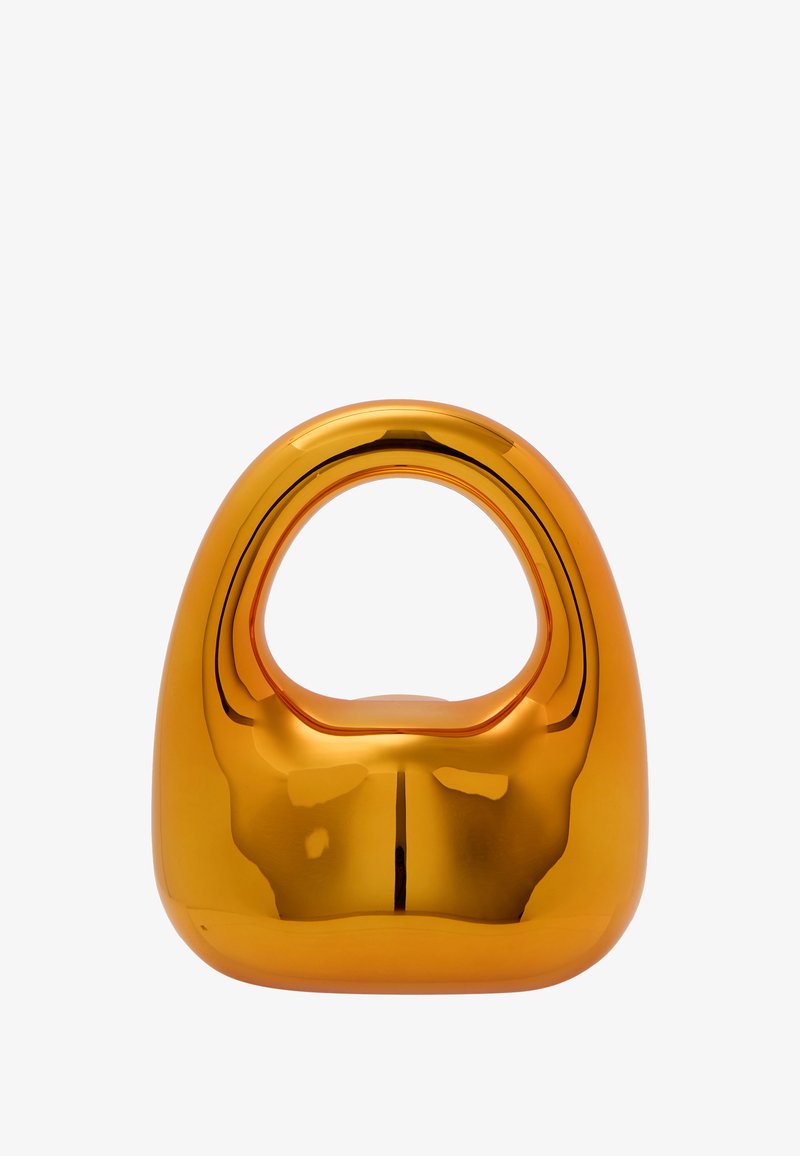 Simogató, narancssárga kerámiából készült tárgy, lekerekített alappal és a tetején fogantyú alakú nyílással. Tükröződő felülete kiemeli sima textúráját.