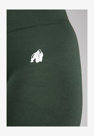 Groene leggings van rekbaar materiaal met een gladde textuur. Kenmerkt een wit gorilla-logo aan de linkerkant bij de tailleband.