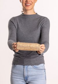 Goldfarbener, zylindrischer Beutel, der in Händen gehalten wird. Die Oberfläche weist ein Lochmuster auf, hat eine weiche Stoffoberfläche und nahtlose Kanten.