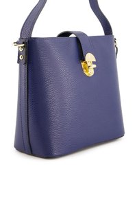 Purple leather handbag with a structured shape, textured surface, gold hardware, and a flap closure. Features an adjustable shoulder strap.