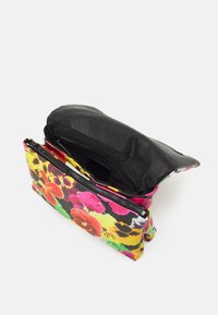 Borsa in pelle nera con borsa per il trucco con zip colorata e floreale attaccata, aperta per mostrare l'interno nero su sfondo bianco.