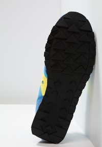 Blue and yellow athletic shoe with a black rubber sole featuring triangular tread patterns, suede and synthetic upper material.