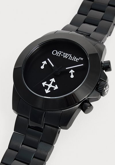 Montre-bracelet Off-White en acier inoxydable noir avec cadran noir, flèches blanches sur les aiguilles et au centre, et bracelet en maillons métalliques polis.