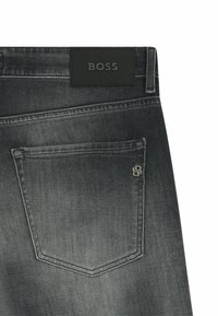 Jeans in denim grigio scuro con una patch in pelle con il marchio "BOSS" in vita, una tasca posteriore discreta e dettagli metallici.