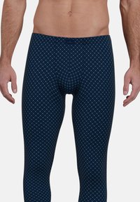 Marinefarbene Leggings mit einem geometrischen Diamantenmuster in Hellgrün, aus dehnbarem Material gefertigt, mit einer körpernahen Passform und ohne sichtbare Beschläge.