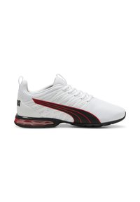 Weißer Sportschuh mit einem strukturierten Mesh-Obermaterial, roten und schwarzen Akzenten, einer schwarzen Sohle und sichtbarer Luftpolsterung in der Ferse.