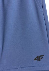 Tissu bleu texturé avec une poche latérale et un logo noir "4F" imprimé près de l'ourlet inférieur.