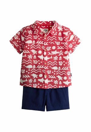 Czerwona koszula na krótki rękaw z białymi, oceanicznymi motywami, zestawiona z granatowymi szortami dla malucha.