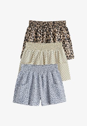 Trzy pary szortów z elastycznym pasem ułożone jedna na drugiej, z nadrukiem w panterkę, czarnymi kropkami na beżowym tle oraz białym kwiatowym wzorem na niebieskim tle.