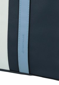 Bolso de cuero sintético texturizado en azul marino con toques en azul claro y un detalle del logo. Presenta una forma estructurada y un diseño bicolor.