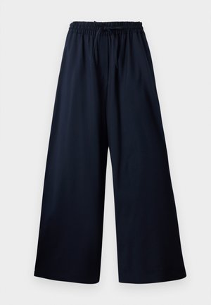 Pantalons larges en tissu bleu marine, dotés d'une taille élastique avec un cordon, texture lisse et sans motifs ni accents visibles.