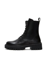 Bottes noires en cuir à la cheville avec un devant lacé, bout rond et semelle en caoutchouc épaisse avec des ridges texturées. Comprend une languette à l'arrière.