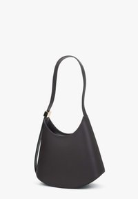 Černá kožená kabelka přes rameno s zakřiveným, asymetrickým tvarem, hladkou texturou a zlatým kováním na popruhu.