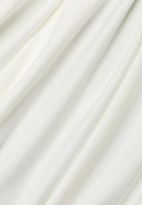 Witte zachte stof met een subtiele ribbeltextuur, elegant draperend met zachte plooien. Lichtgewicht en soepel, ideaal voor verschillende kledingtoepassingen.