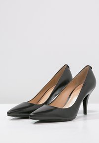 Escarpins noirs en cuir avec un bout pointu, un design élégant et un talon aiguille fin. L'intérieur est doté d'une doublure en cuir lisse de couleur beige.