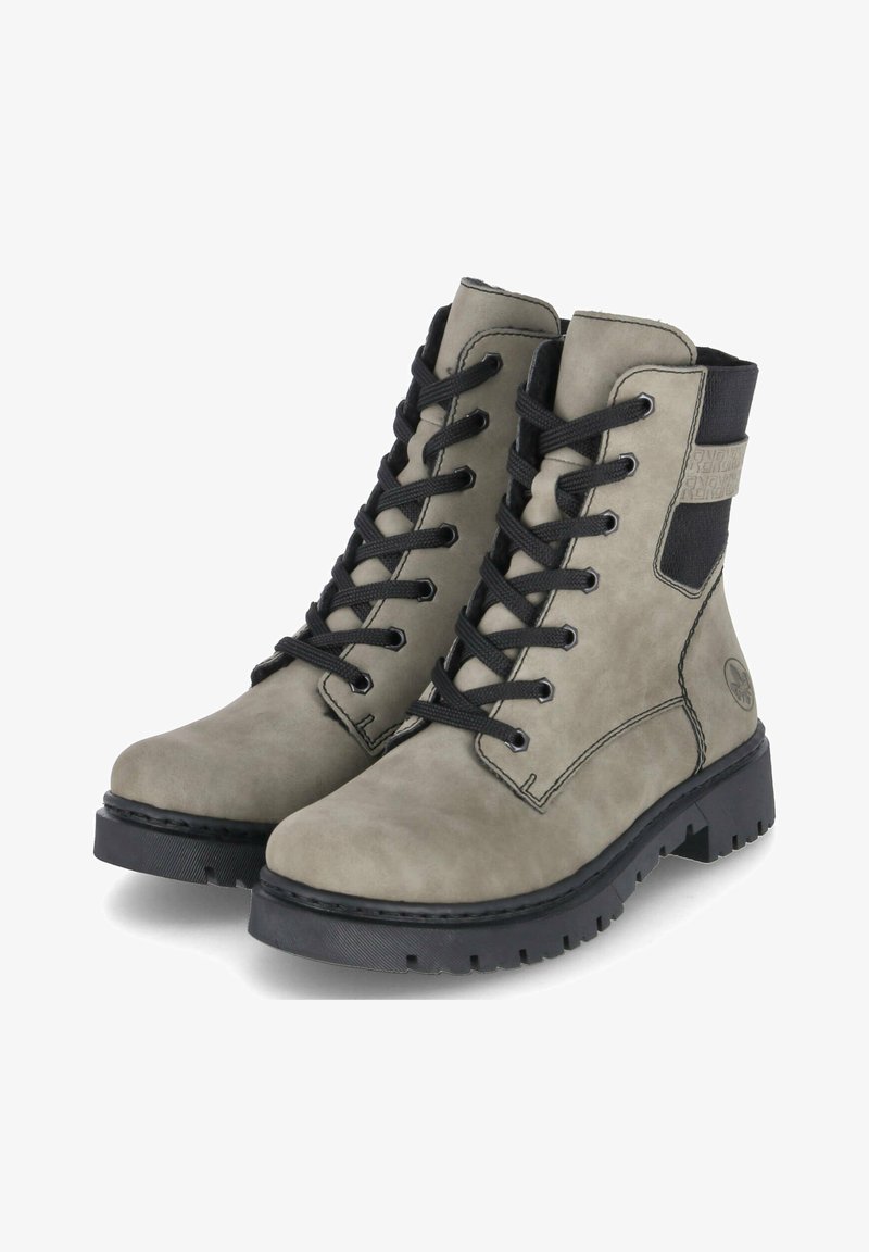 Botas de ante gris hasta el tobillo con cordones negros, punta redonda y suela de goma negra gruesa. Presenta un panel lateral elástico y un logo grabado.