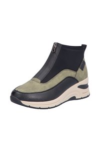 Baskets avec fermeture éclair, fabriquées en cuir vert olive et tissu noir, dotées d'une semelle noire texturée et d'un léger talon compensé pour la hauteur.