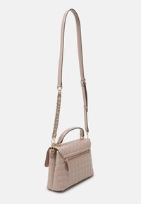 Prošívaná béžová kabelka se strukturovaným designem, obsahující horní rukojeť, nastavitelný popruh a zlaté kovové detaily s kapsou na zip.