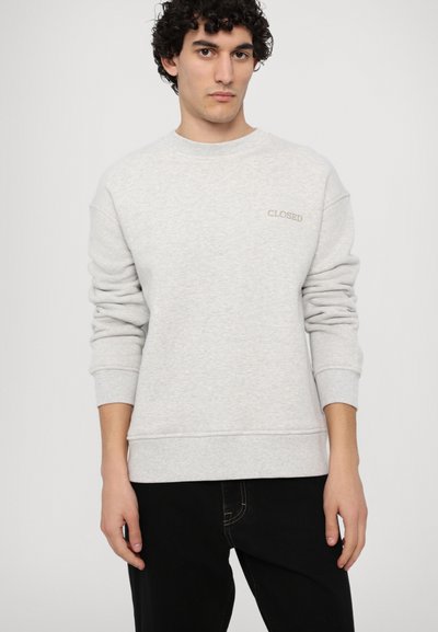 Light grey sweatshirt made of soft fabric. Features a round neck, long sleeves, ribbed cuffs, and a small "CLOSED" logo on the chest.