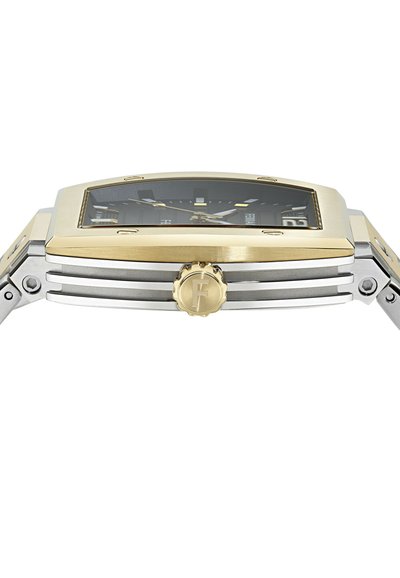 Prostokątny zegarek ze stali nierdzewnej i złotym wykończeniem, z czarną tarczą, srebrnymi wskazówkami i widoczną koronką. Posiada teksturowaną lunetę i bransoletę z ogniw.