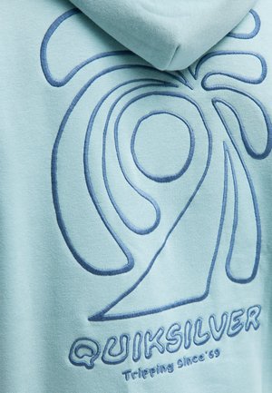 Jasnoniebieska bluza z kapturem z dużym, wypukłym, ciemnoniebieskim haftowanym wzorem spirali oraz napisem "QUIKSILVER" w gładkiej czcionce na dole.