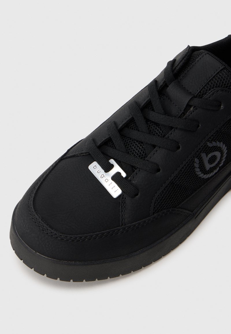 Sneaker Bugatti noir en cuir texturé, avec un panneau latéral en maille, des lacets noirs et une étiquette de marque argentée sur les lacets près des orteils.