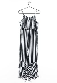 Schwarzer und weiß gestreifter Jumpsuit mit figurbetontem Oberteil, Spaghetti-Trägern und Rüschensaum. Hergestellt aus leichtem Material, hängt an einem Haken.
