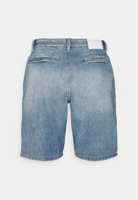 Pantalones cortos de denim azul claro con un corte clásico, dos bolsillos traseros y dobladillo enrollado. La tela presenta una textura desgastada.