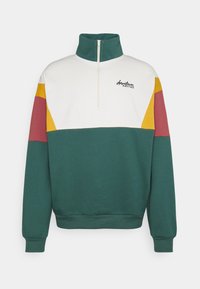 Grön, vit och flerfärgad zip-tröja; har en hög krage, ribbade ärmar och en logotyp på bröstet; material i bomullsblandning.