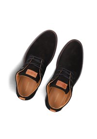 Zwarte suède schoenen met bruine leren accenten, ronde neus, vetersluiting en een beige interieur. Klein logo op de hiel.