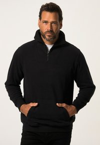 Zwarte zip-up sweatshirt met een hoge kraag, voorzakken en lange mouwen. Stof lijkt zacht met een gladde textuur en minimale ontwerpelementen.