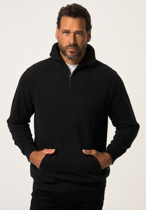 Sort lynlås sweatshirt med høj krave, frontlommer og lange �ærmer. Stoffet ser blødt ud med en glat tekstur og minimale designdetaljer.