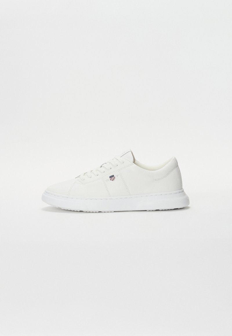 Sneaker bianco in pelle, con una texture liscia, punta arrotondata, design con lacci e suola in gomma a profilo basso con marchio discreto.