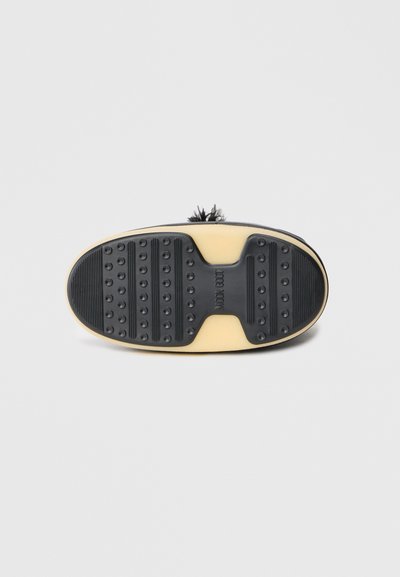 Sole de pantof din cauciuc negru, cu o suprafață texturată, dotată cu prinderi circulare și modele nervurate. Zona centrală a logo-ului este distinctivă.