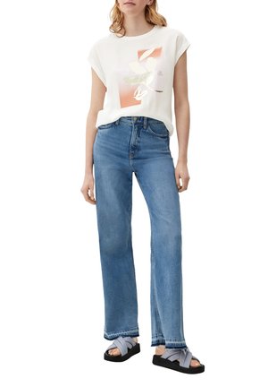 Weißes T-Shirt mit kurzen Ärmeln und floralem Grafikaufdruck, kombiniert mit hoch taillierten blauen geraden Jeans und schwarzen Sandalen mit grauen Riemen.