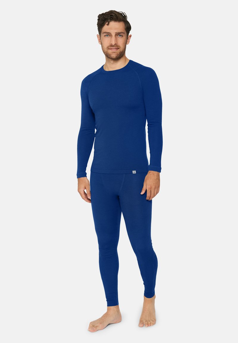 Sininen pitkähihainen thermal-paita ja legginsit, jotka on valmistettu pehmeästä ja joustavasta kankaasta. Istuva malli, jossa on litteät saumat ja pieni logotieto.